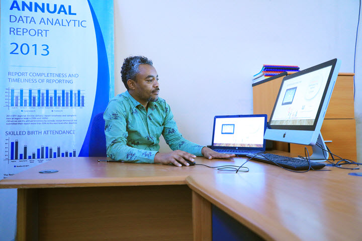 Mohammed, seated at a desk, displays a MERL data analytics report.